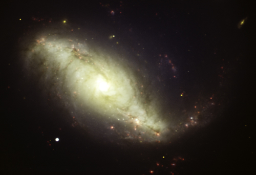 This colorful image shows the barred spiral galaxy NGC 7552. The colors represent different wavelengths of light captured by separate filters: red (H-alpha), blue (g), green (r), and yellow (i).