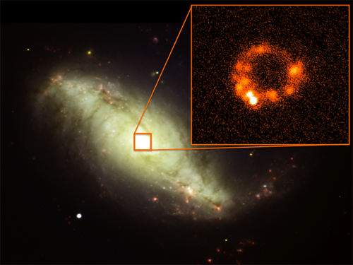 This composite image shows the barred spiral galaxy NGC 7552. The main image is a visible-light view. The inset shows a mid-infrared image (red) revealing a ring of dust clouds around the galaxy's center.