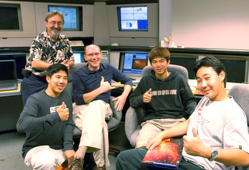 The Gemini student observation team celebrate after obtaining excellent data (shown on screen in background) on comet 73P/Schwassmann-Wachmann 3 using the Gemini North 8-meter telescope.