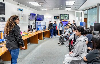 La experta en comunicación y difusión, Fernanda Urrutia, conversa con estudiantes en la Sala de Control del Recinto AURA