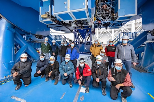 Imagen del personal de NOIRLab en la planta Gemini South con el instrumento GHOST al fondo.